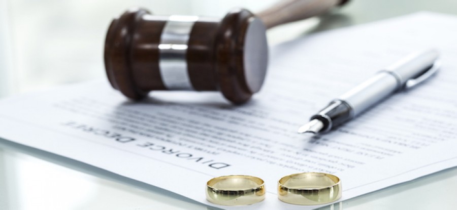 Divorce decree and wedding rings with pen and gavel Divorce decree and wedding rings with pen and gavel