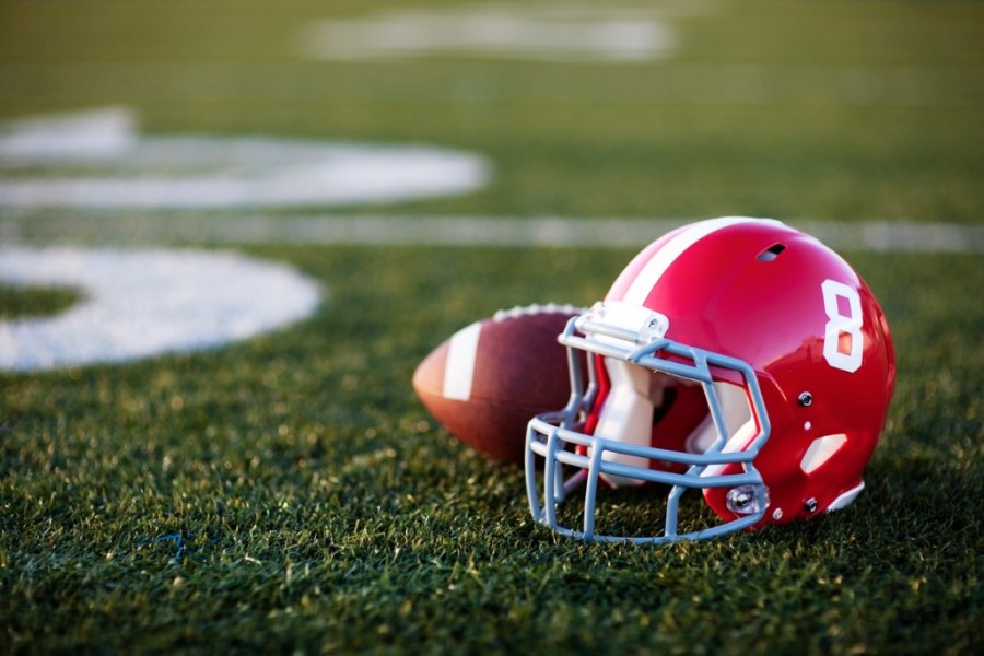 American Football Helmet and Ball On A Field American Football Helmet and Ball On A Field