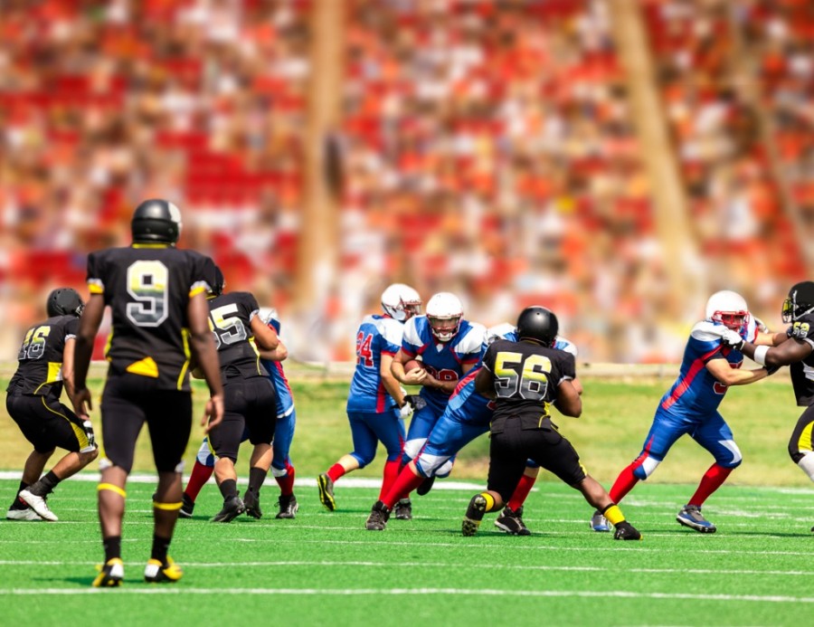 American football running back carrying ball through defenders American football running back carrying ball through defenders