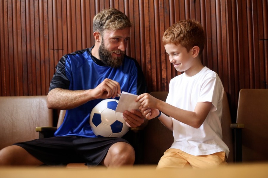 Athlete giving autograph to child Athlete giving autograph to child