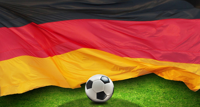 Football on grass in front of German flag