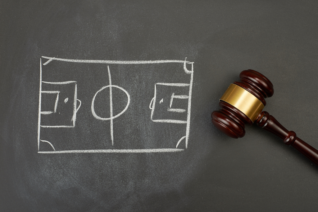 Gavel with football pitch drawn on chalkboard