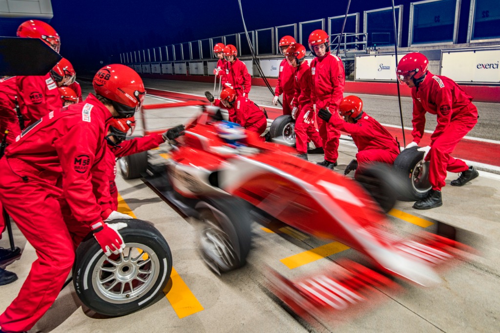 Red formula one car leaving the pit stop