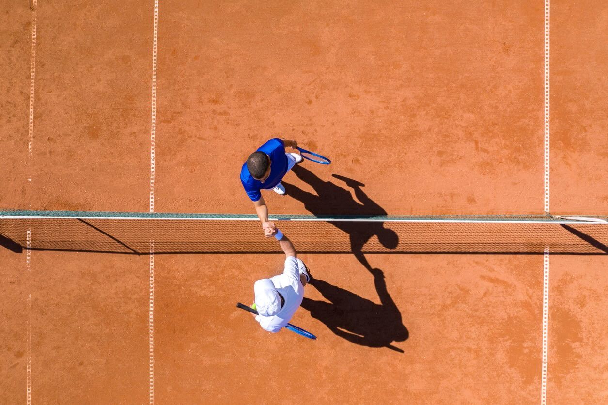 Two Tennis Players Greeting Each Other Over the Net