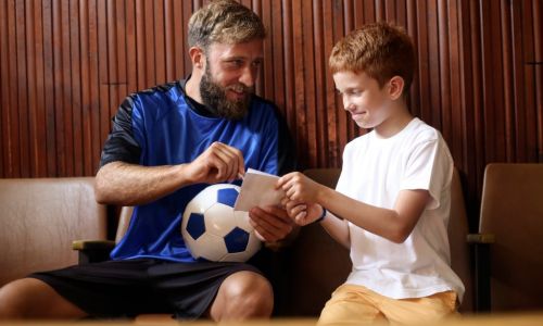 Athlete giving autograph to child