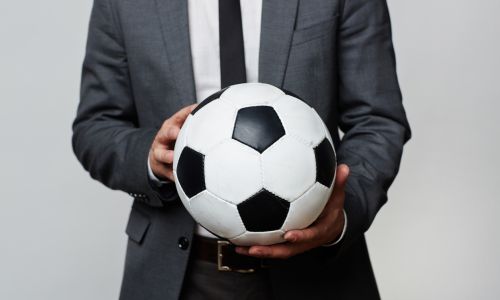 Man in a suit holding a football