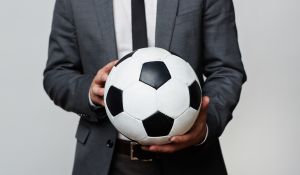 Man in a suit holding a football