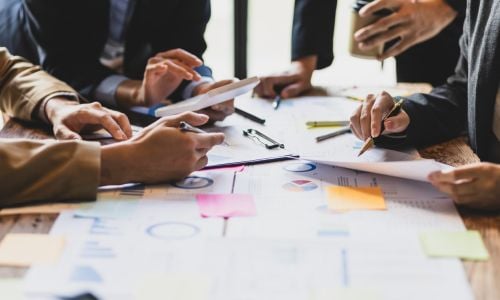 People brainstorming around table with papers